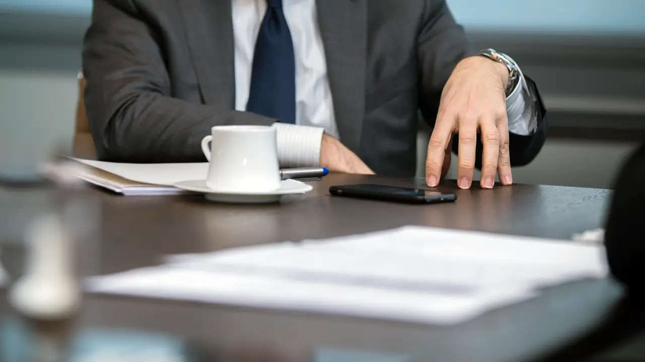 Persona con los dedos en la mesa tratando de explicar un argumento